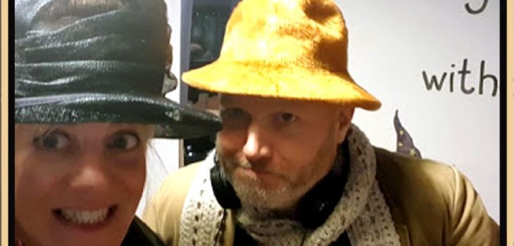 an photo of two people who are looking directoly at the camera. The photo shows the people from the shoulder up. A man is on the right and a women on the left. They are both wearing strange hats.