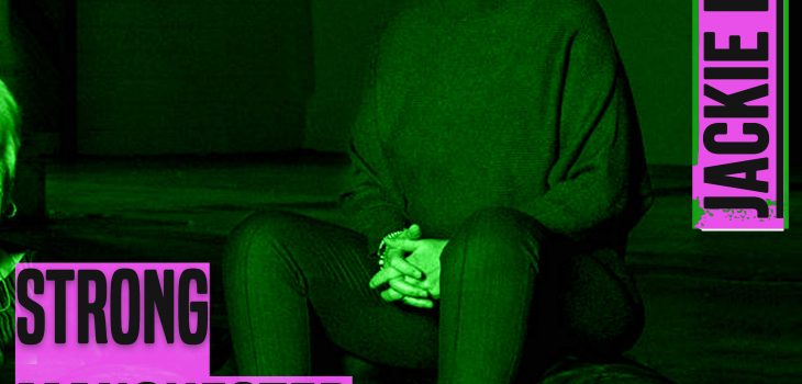 an image of a woman with short brown hair sits on top of a leather chair. The photo is tinged green. On the left of the seated woman are the words 'strong manchester women' and to the top right of the woman are the words 'jackie driver' Both sets of words are in bold grey type.