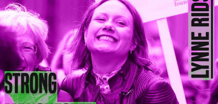Lynne Ridsdale is pictured smiling. The picture has a purple hue to it. On the leff of the picture are the words 'strong manchester women' on the right 'lynne ridsdale' - both in capital and grey colour letters
