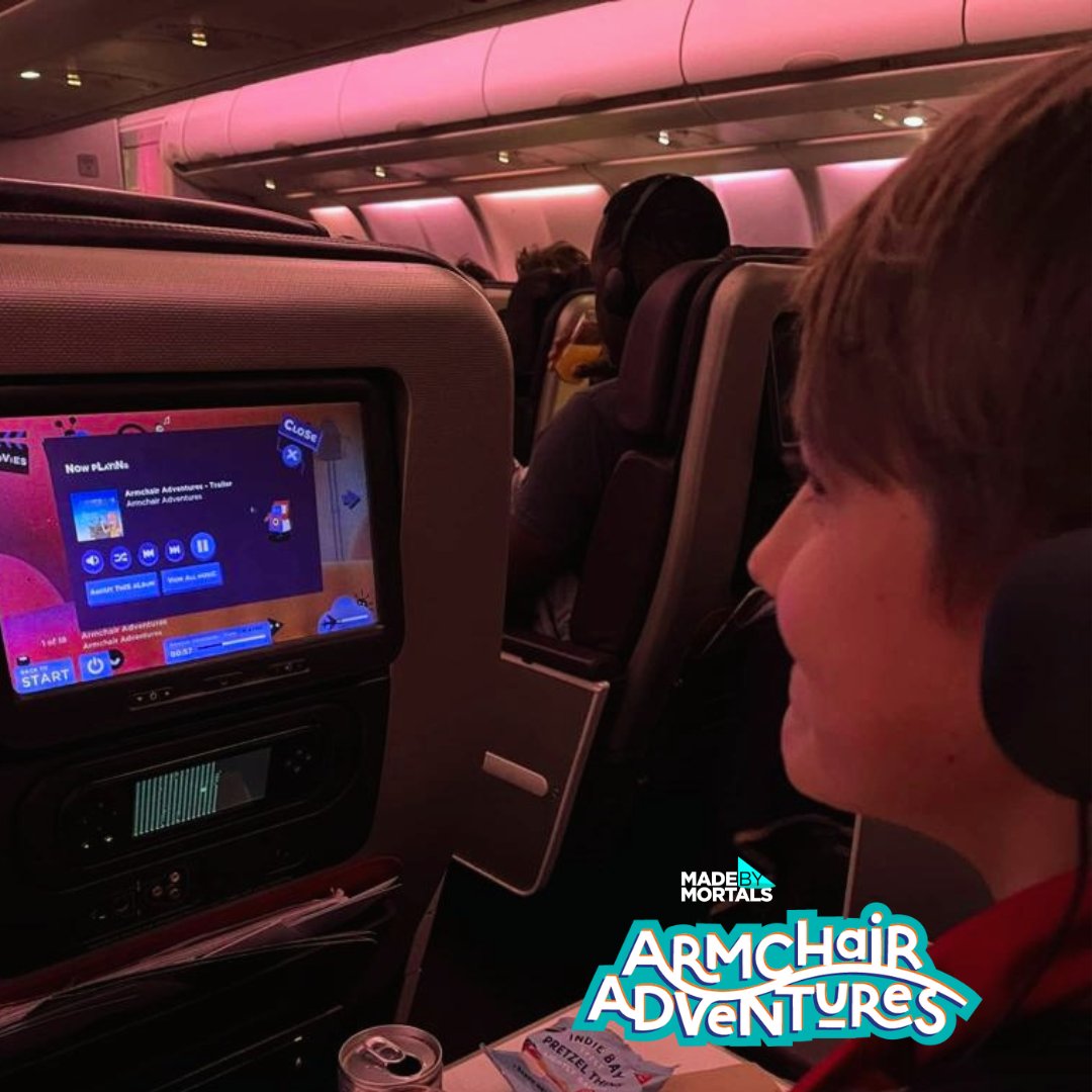 in flight photo of armchair adventures on the screen on the airplane chair